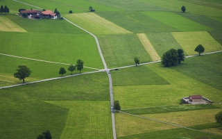 Aerial photography of a rural area, road crossing in the middle of green fields